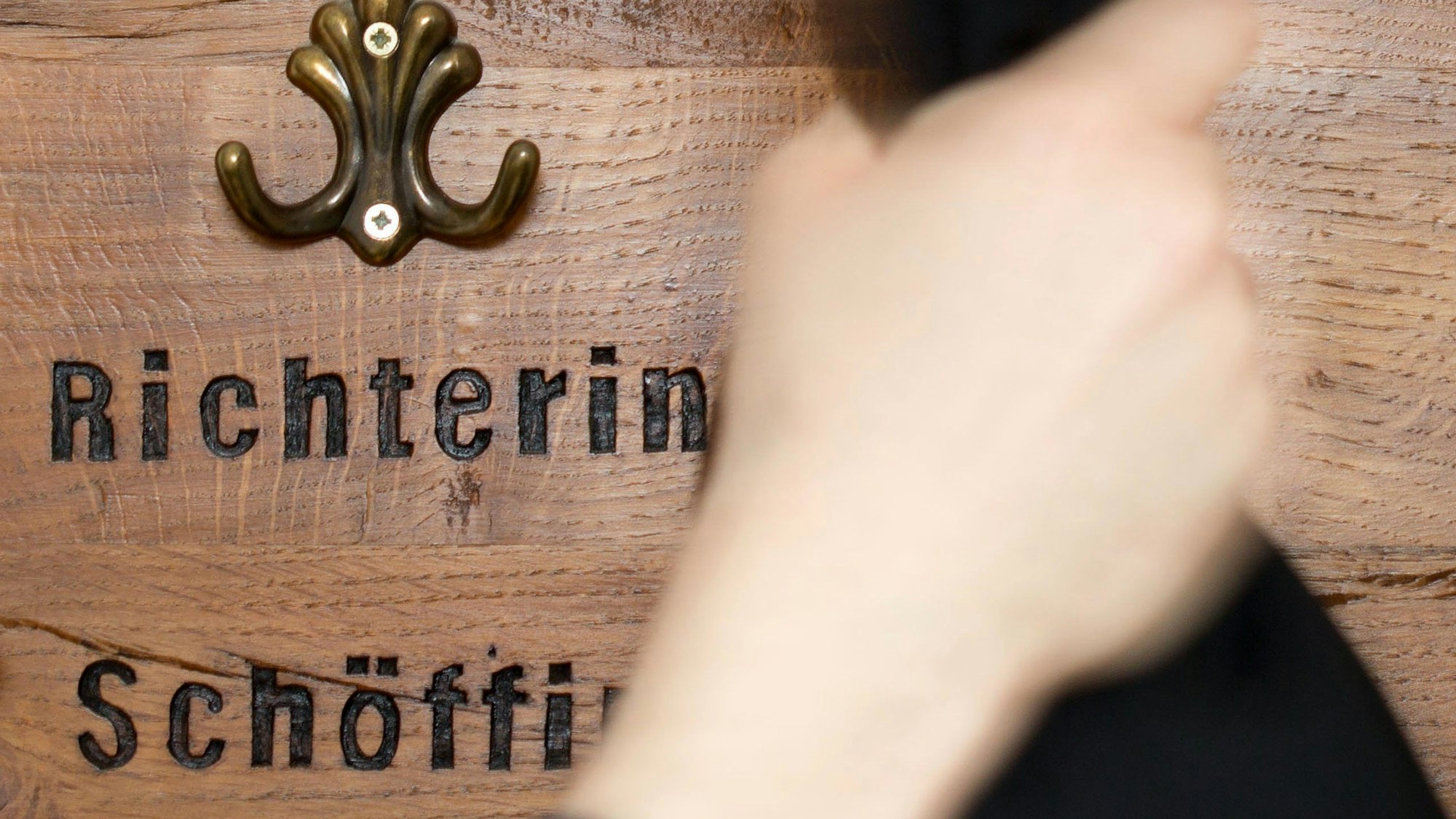 Ein Richter hängt seine Robe an eine Garderobe für Richter und Schöffen