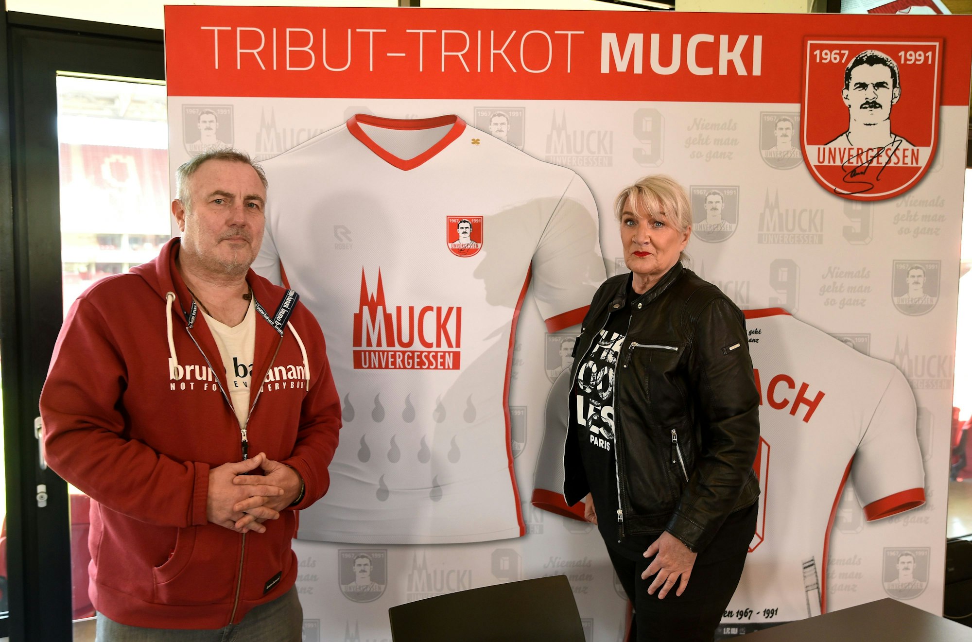 Ex-FC-Profi Andreas Gielchen und Claudia Weigl-Banach stellen im März 2021 im Rhein-Energie-Stadion ein Sondertrikot für Maurice Banach vor.