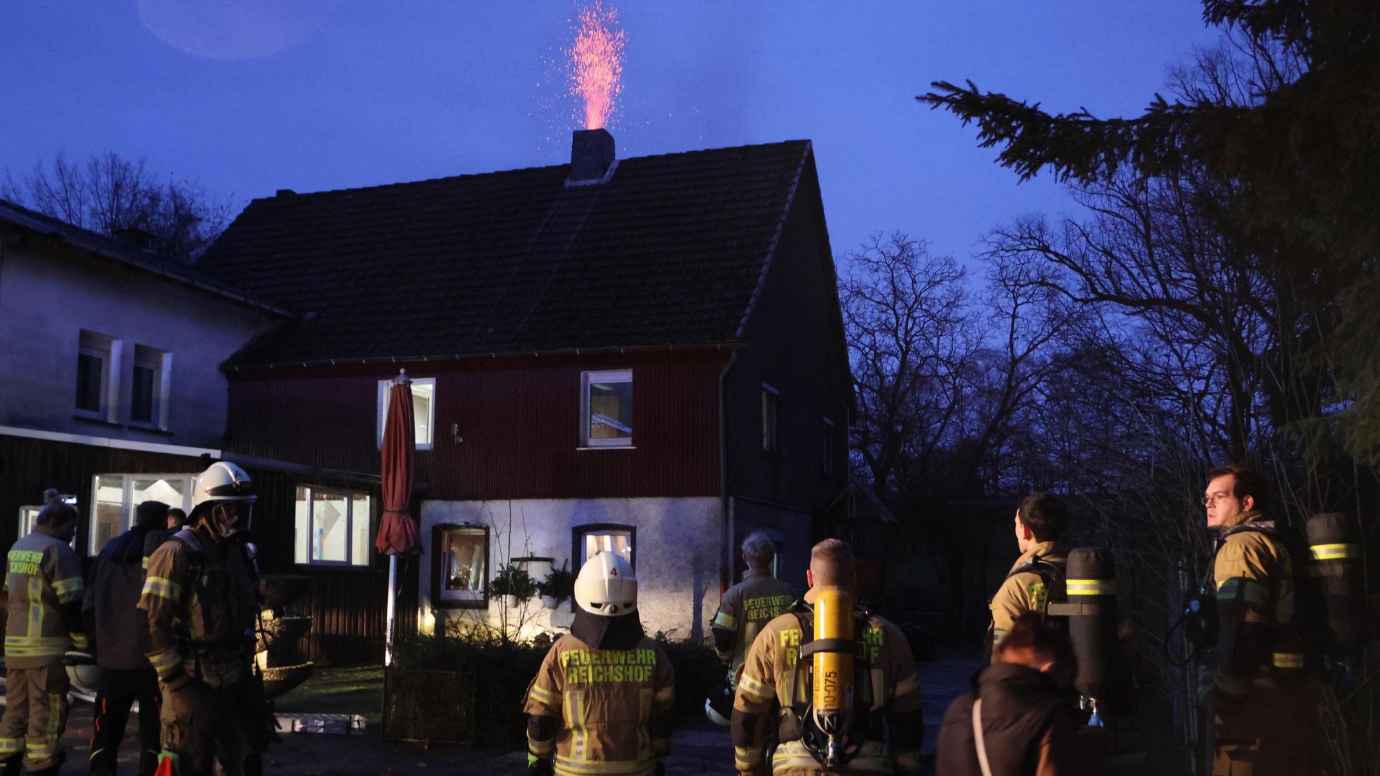 Einsatzkräfte der Freiwilligen Feuerwehr Reichshof stehen am späten Freitagnachmittag am Einsatzort.