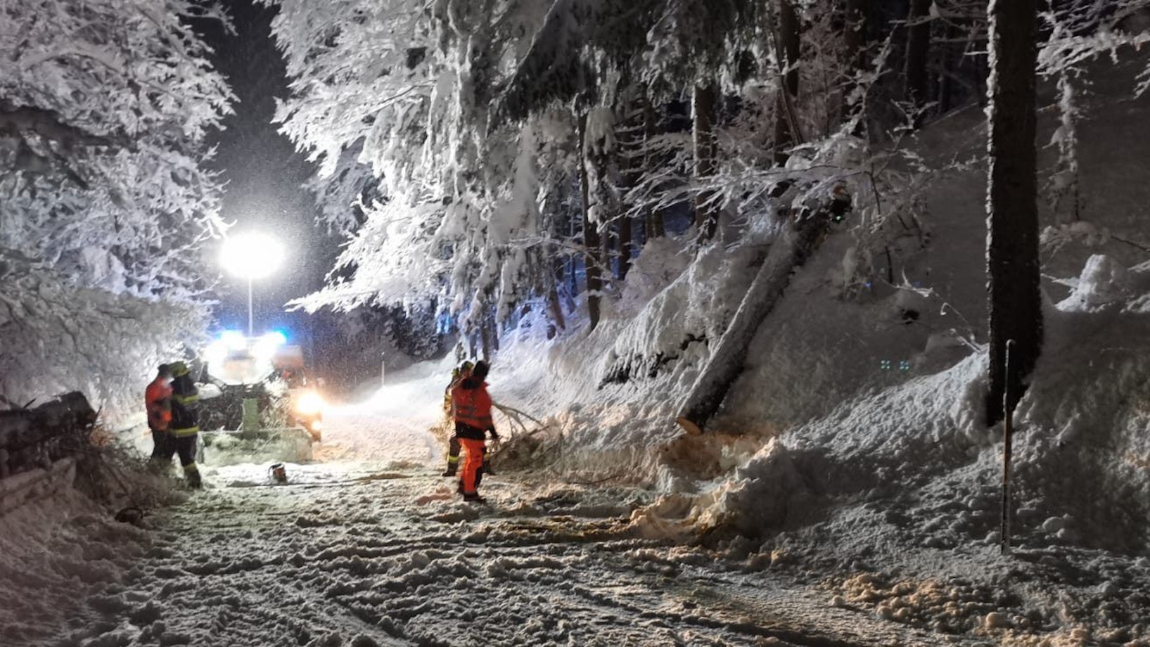 Schneemengen in Österreich. Ein Feuerwehrmann und Helfer sind nach starkem Schneefall im Einsatz.