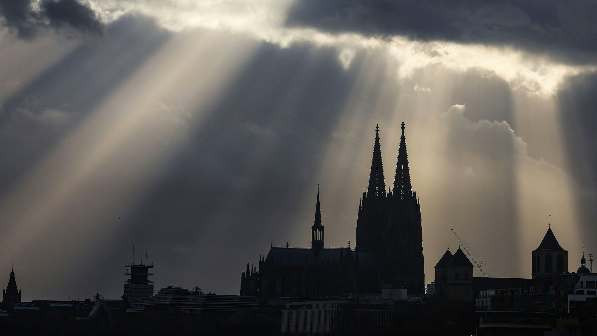 30.01.2023, Nordrhein-Westfalen, Köln: Sonnenstrahlen scheinen hinter dem Dom aus Wolken. Mit dem frostigen Winterwetter ist es in Nordrhein-Westfalen vorerst vorbei. Ein Tiefdruckgebiet bringe von Norden her milde Meeresluft heran. Foto: Oliver Berg/dpa +++ dpa-Bildfunk +++