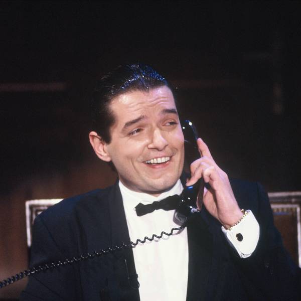 Der Sänger Falco bei einem TV-Auftritt in der Show „Wir gratulieren“ am 6.10.1985. Falco hält einen Telefonhörer und lacht.