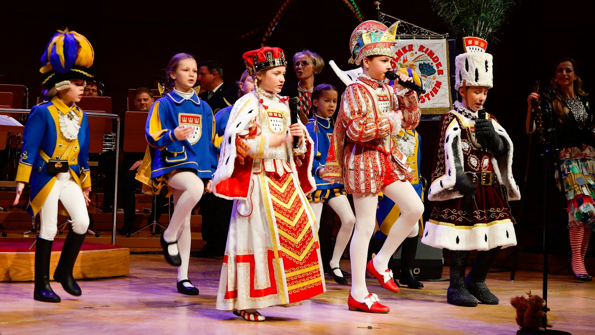 Das Kinderdreigestirn steht auf der Bühne der Kölner Philharmonie.