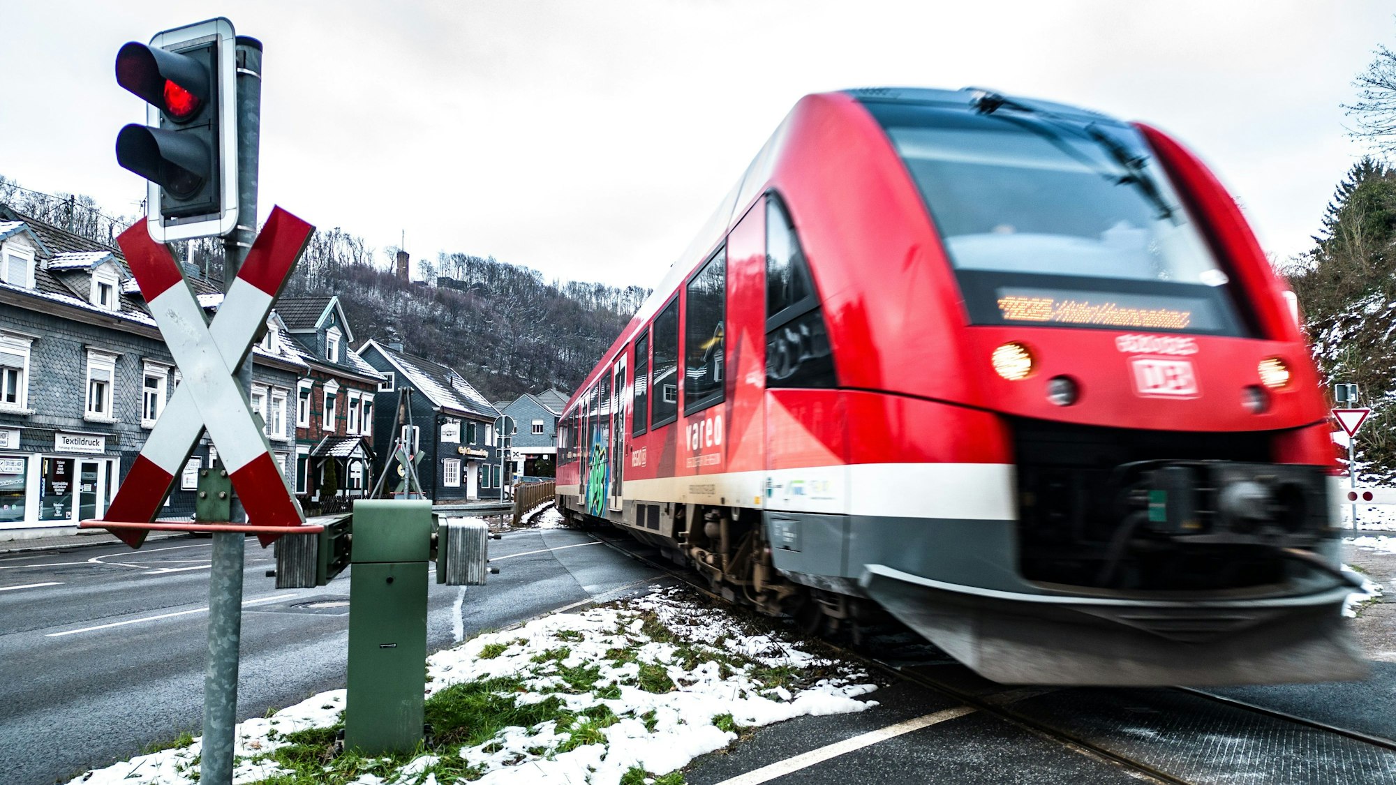Ein Zug der RB 25 überfährt die Bundesstraße 55 am Bahnübergang im Ründerother Ortskern.