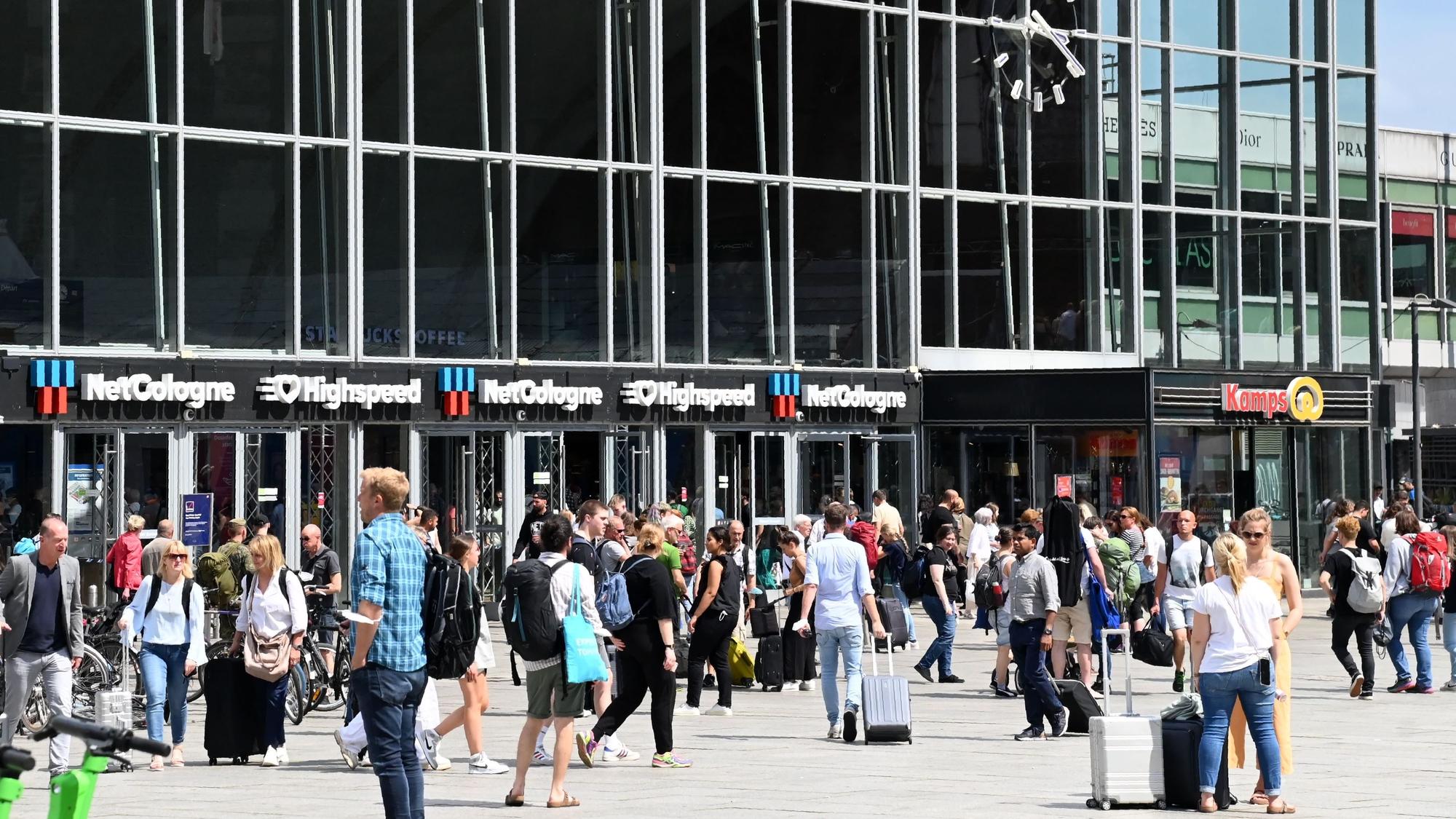 Passanten gehen vor dem Kölner Hauptbahnhof entlang