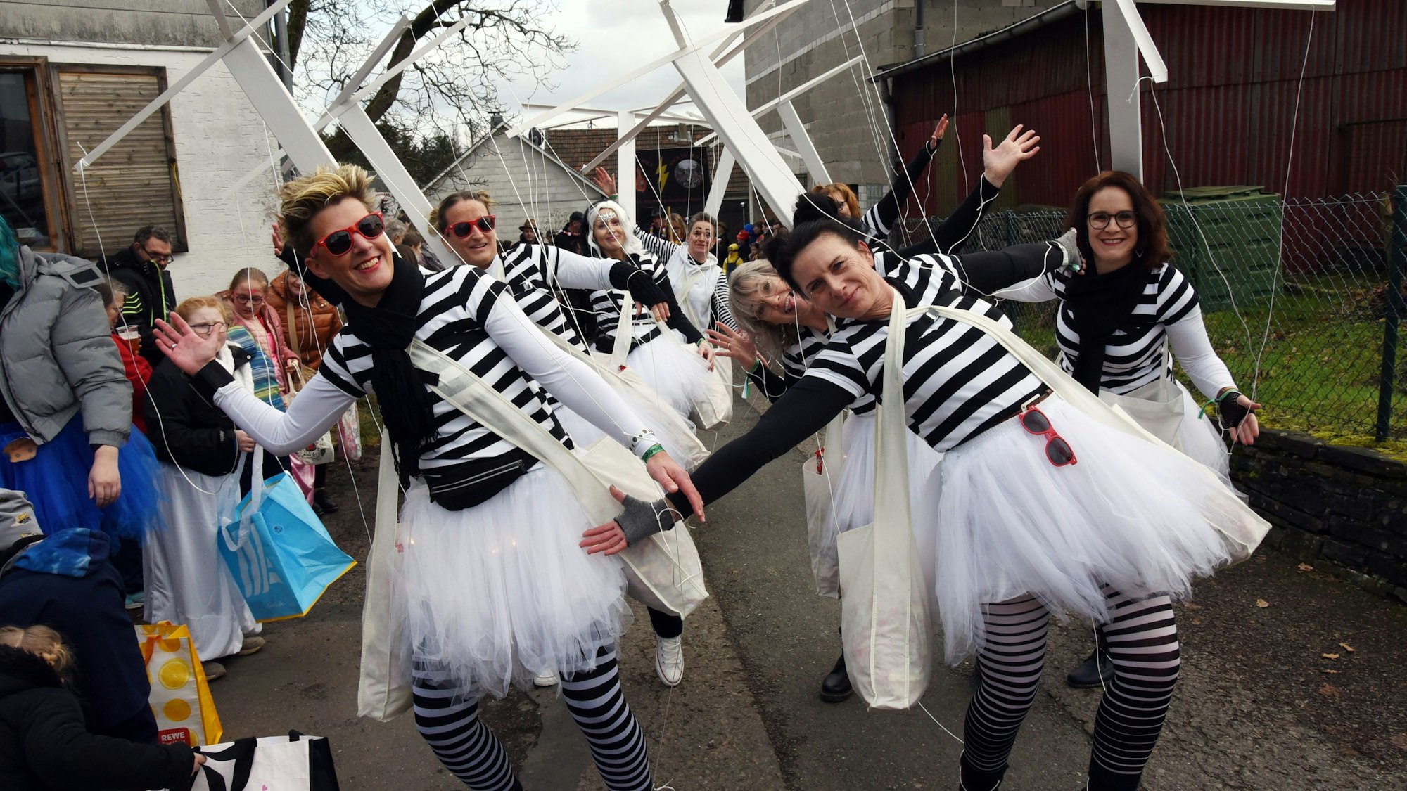 Als schwarz-weiße Marionetten waren die "Schürmicher Määäädchen" ein Blickfang für die Jecken am Zugrand.