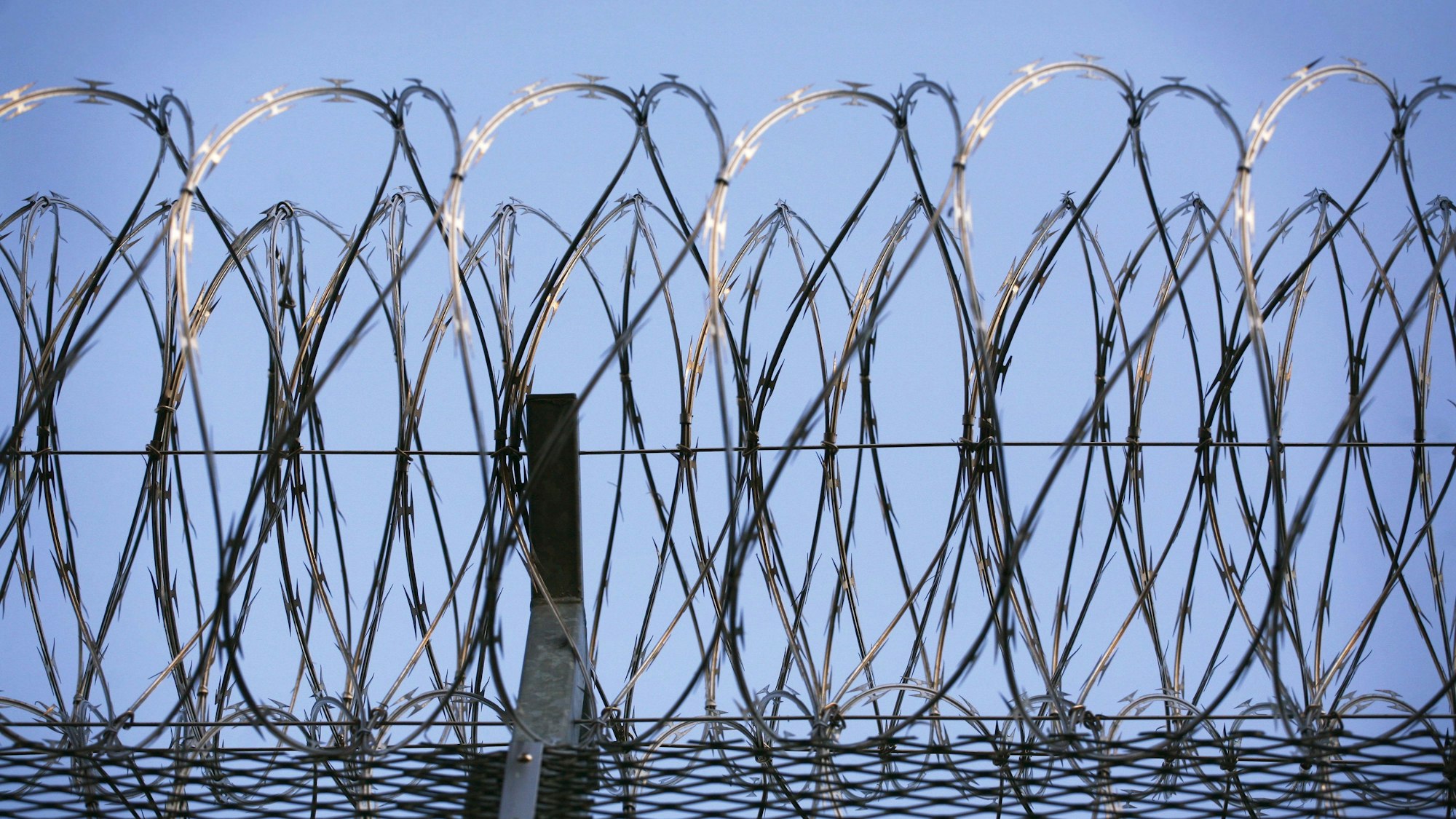 Stacheldraht krönt den Zaun eines Gefängnisses. In den Gefängnissen gebe es Trinkwasser- und Lebensmittelvorräte. Bei länger dauerndem Stromausfall müsste in einigen Justizvollzugsanstalten aber auf Kaltverpflegung umgestellt werden.