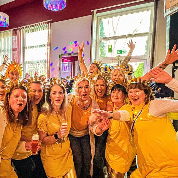 Feiernde Frauen bei der Damensitzung in Kostümen als Sonnenscheinchen.