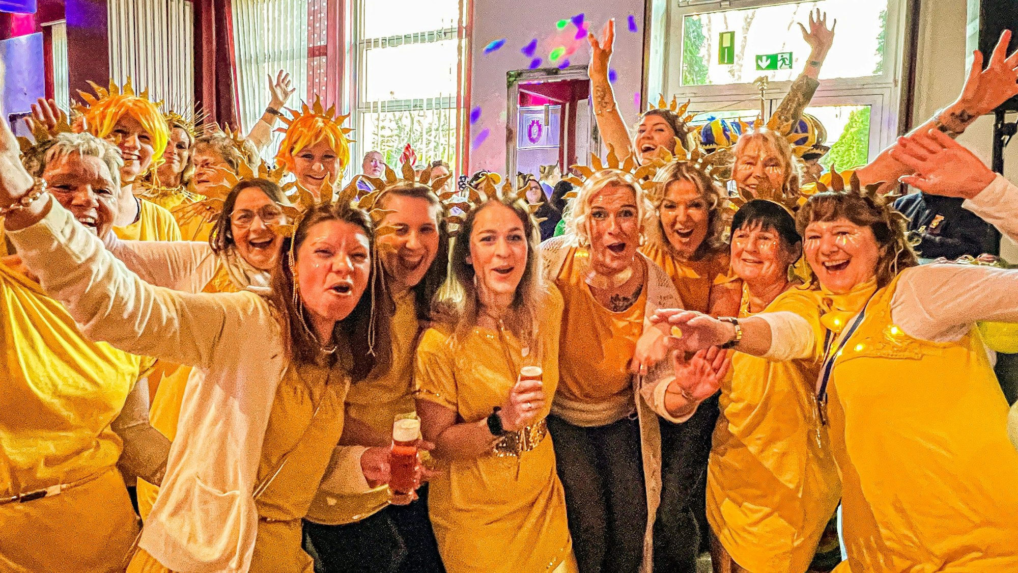 Feiernde Frauen bei der Damensitzung in Kostümen als Sonnenscheinchen.