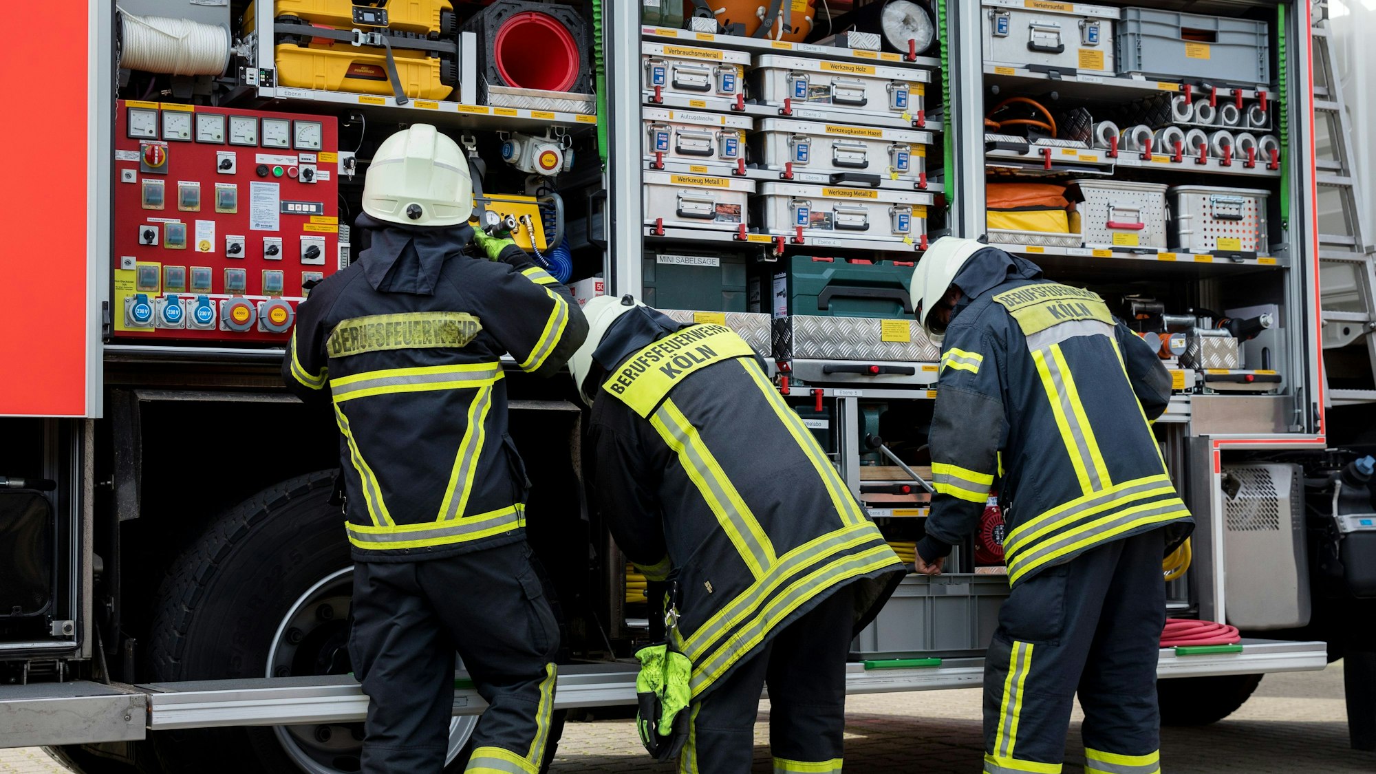 Feuerwehrleute stehen an einem Feuerwehrauto