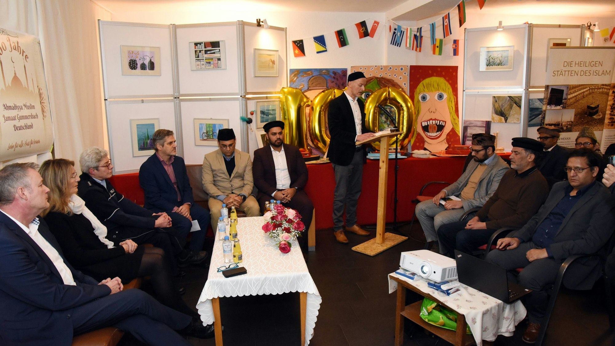 Eine Gruppe von Menschen sitzt in einem festlich geschmückten Raum.