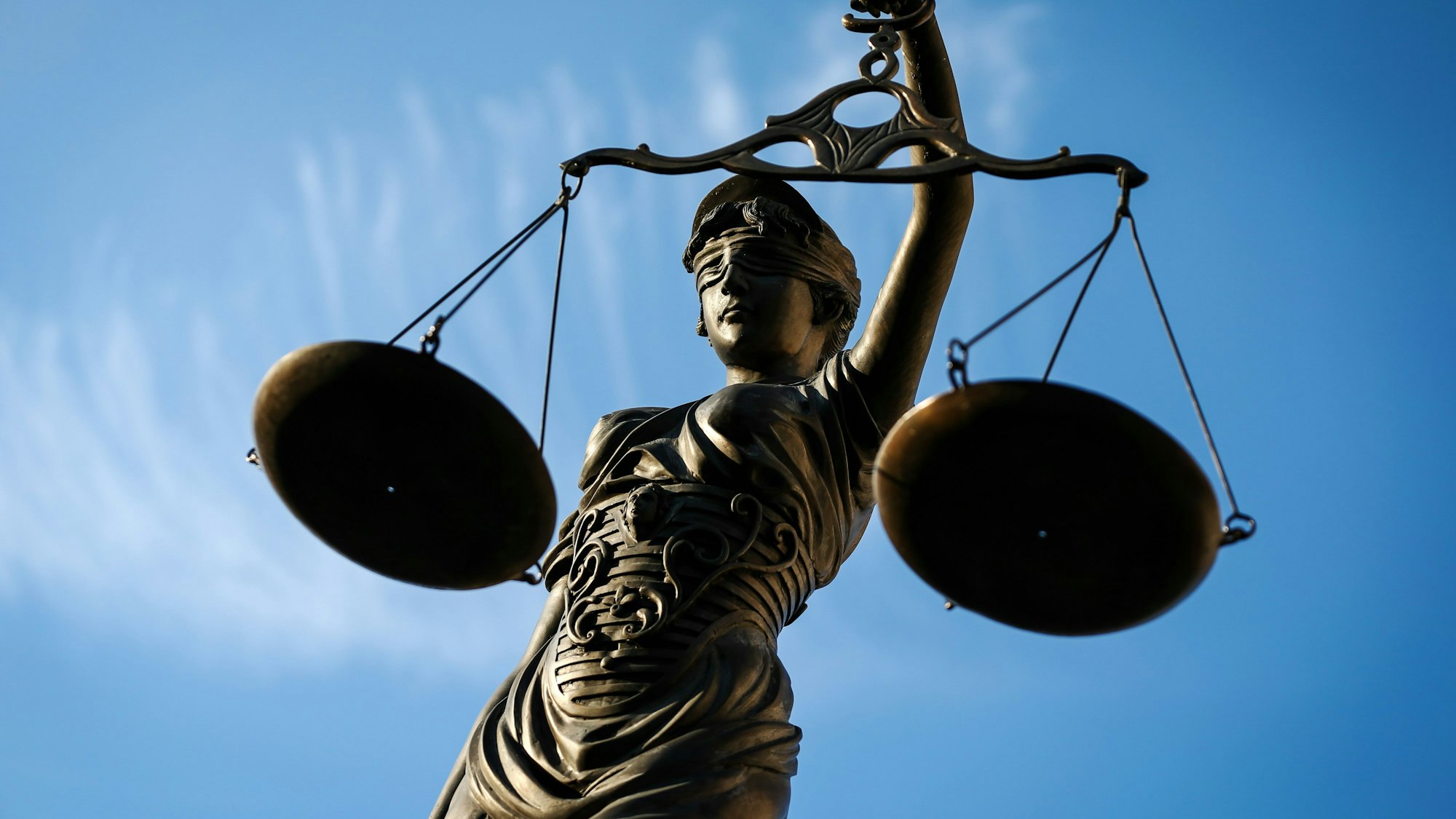 Eine Statue der Justitia hält eine Waage in der Hand.