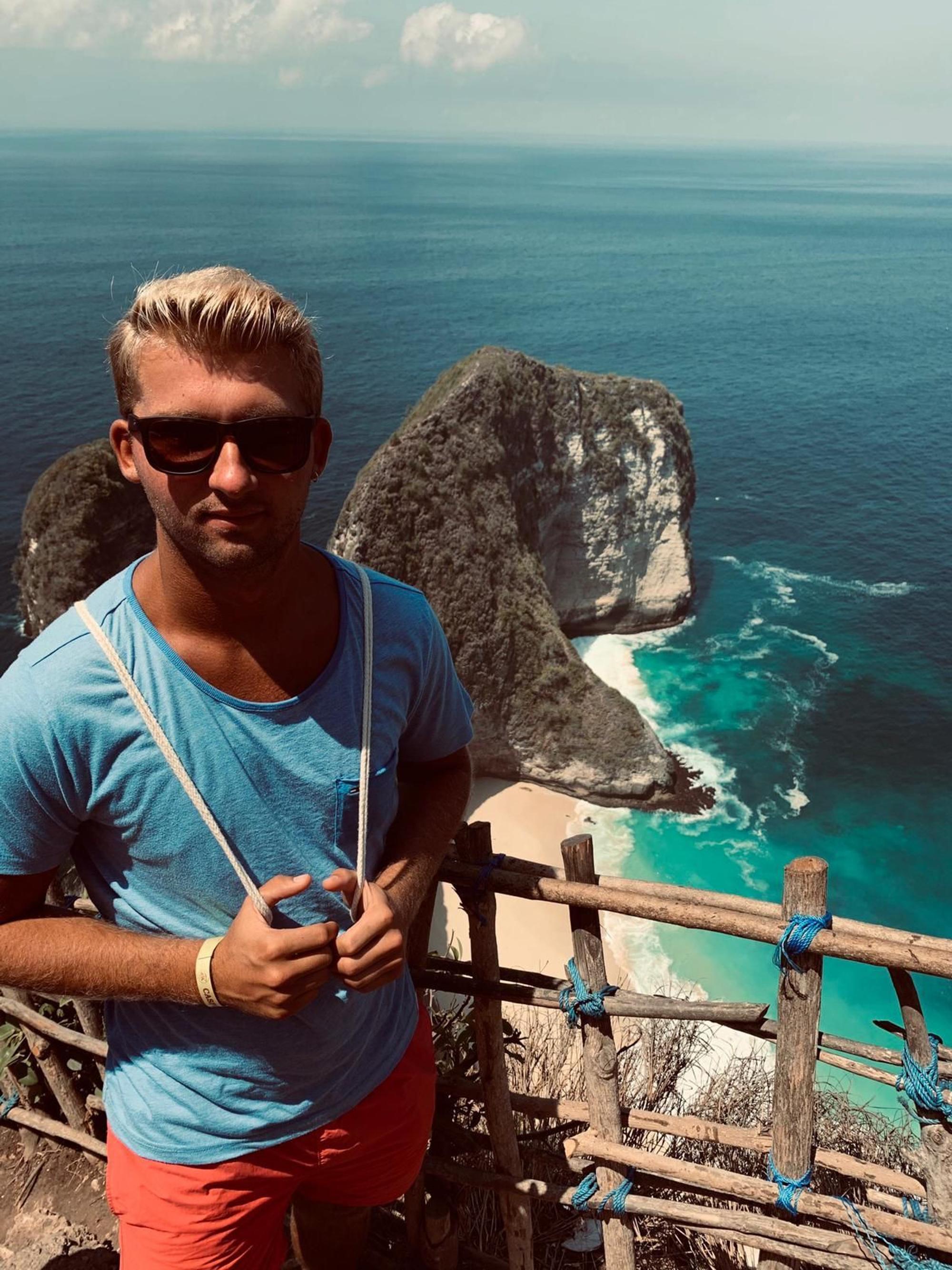 Nico Raddatz trägt bei einem Urlaub in Spanien vor der Kulisse des Mittelmeers eine Sonnenbrille.