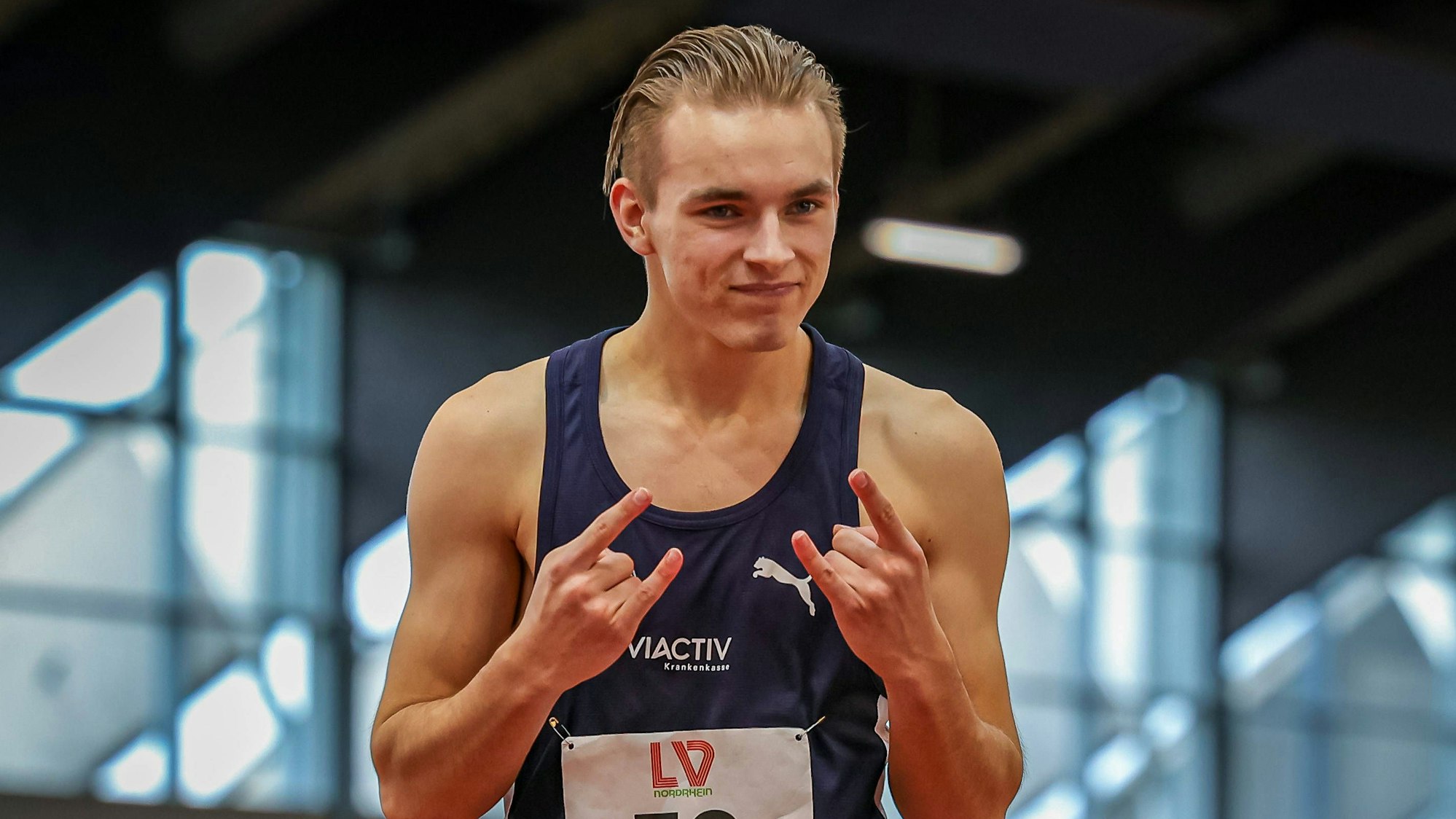 Ein Leichtathlet spreizt nach seinem Wettkampf die Finger.