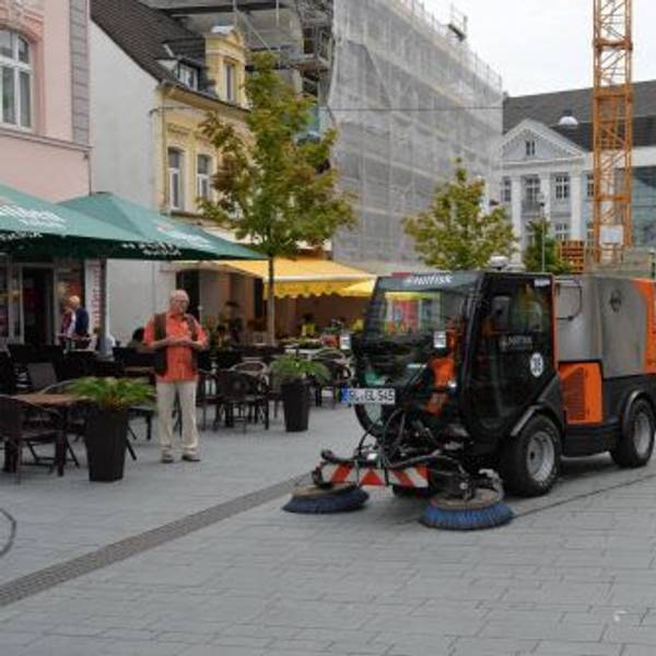 Eine Kehrmaschine säubert das Pflaster der Fußgängerzone in Bergisch Gladbach.