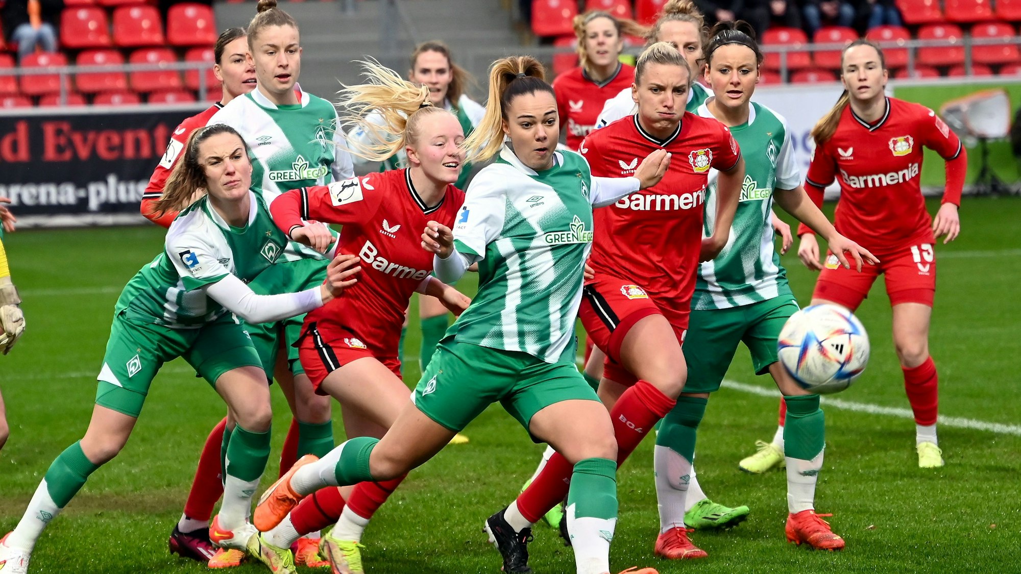 Mehrere Fußballspielerinnen zweier Teams kämpfen im Strafraum um den Ball.