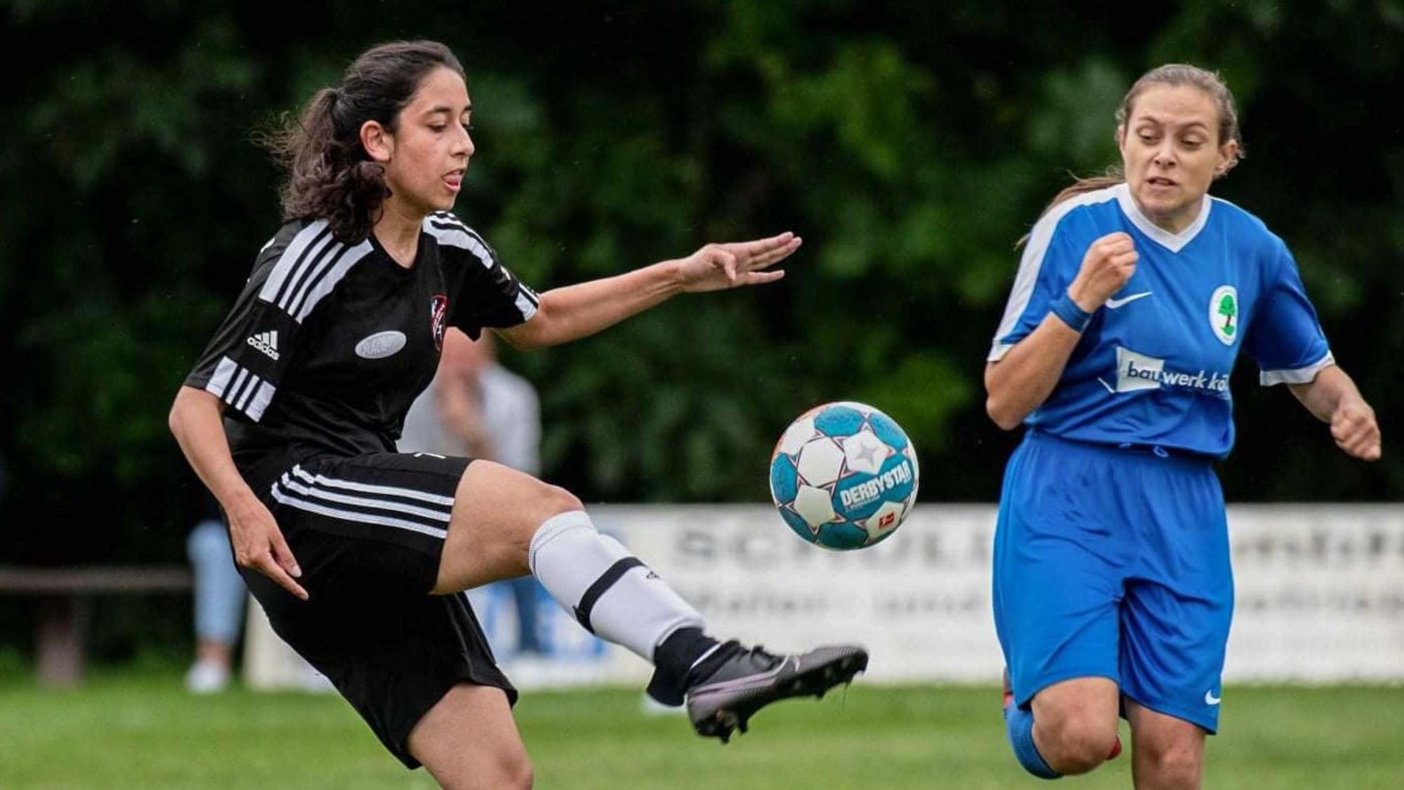 Fußballerin Fijola Misini (schwarzes Trikot) spielt eine Gegnerin aus.