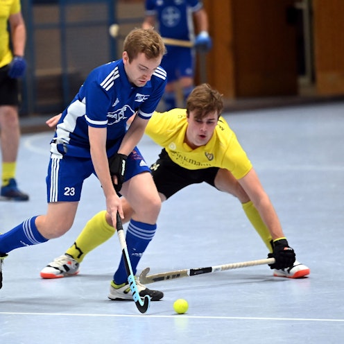 Ein Hockeyspieler läuft an seinem Gegner vorbei.