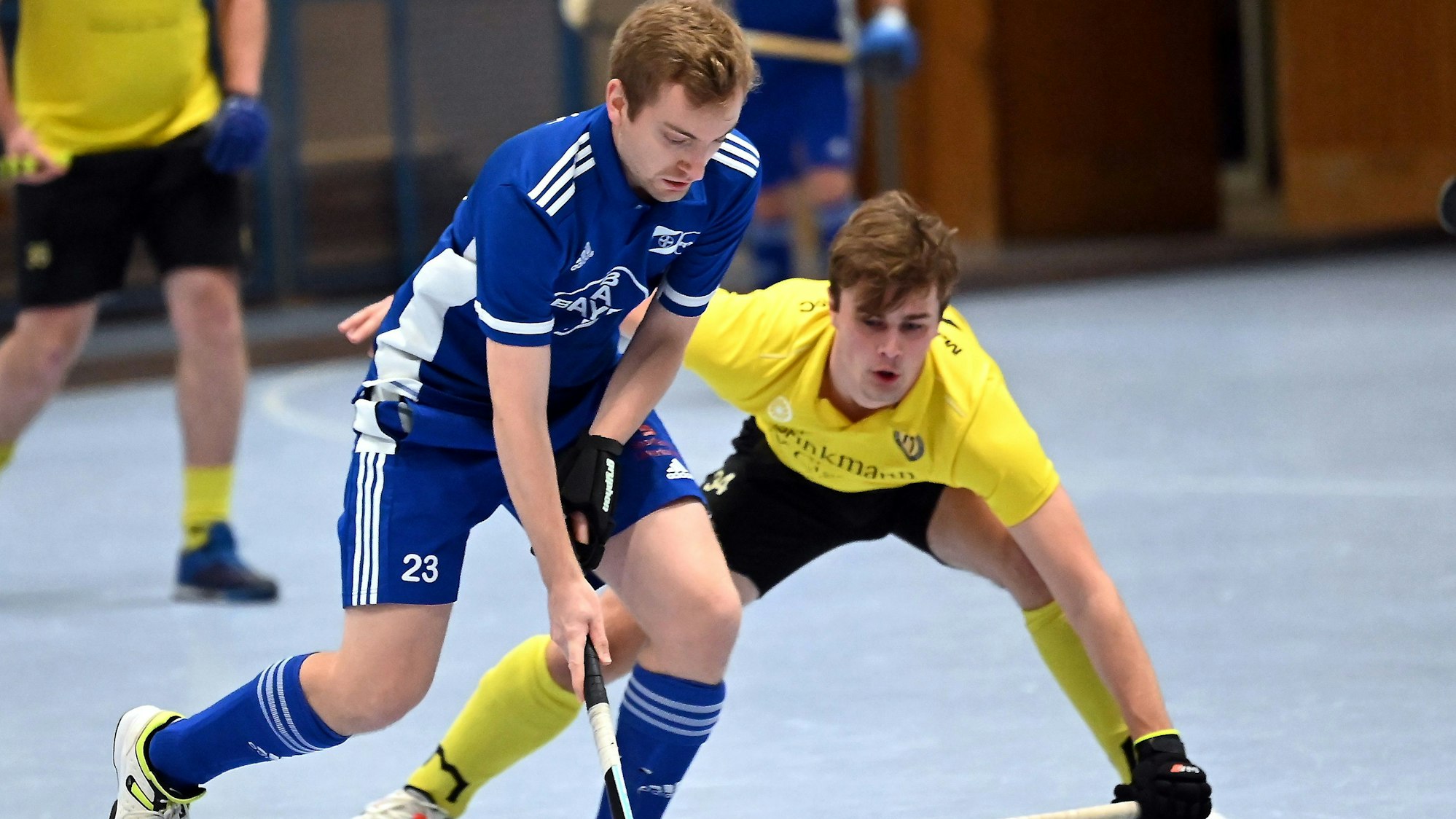 Ein Hockeyspieler läuft an seinem Gegner vorbei.