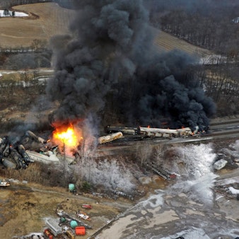 Ein mit einer Drohne aufgenommenes Foto zeigt Teile eines Güterzugs in Flammen und zerstörte Waggons. Schwarzer Rauch steigt auf.