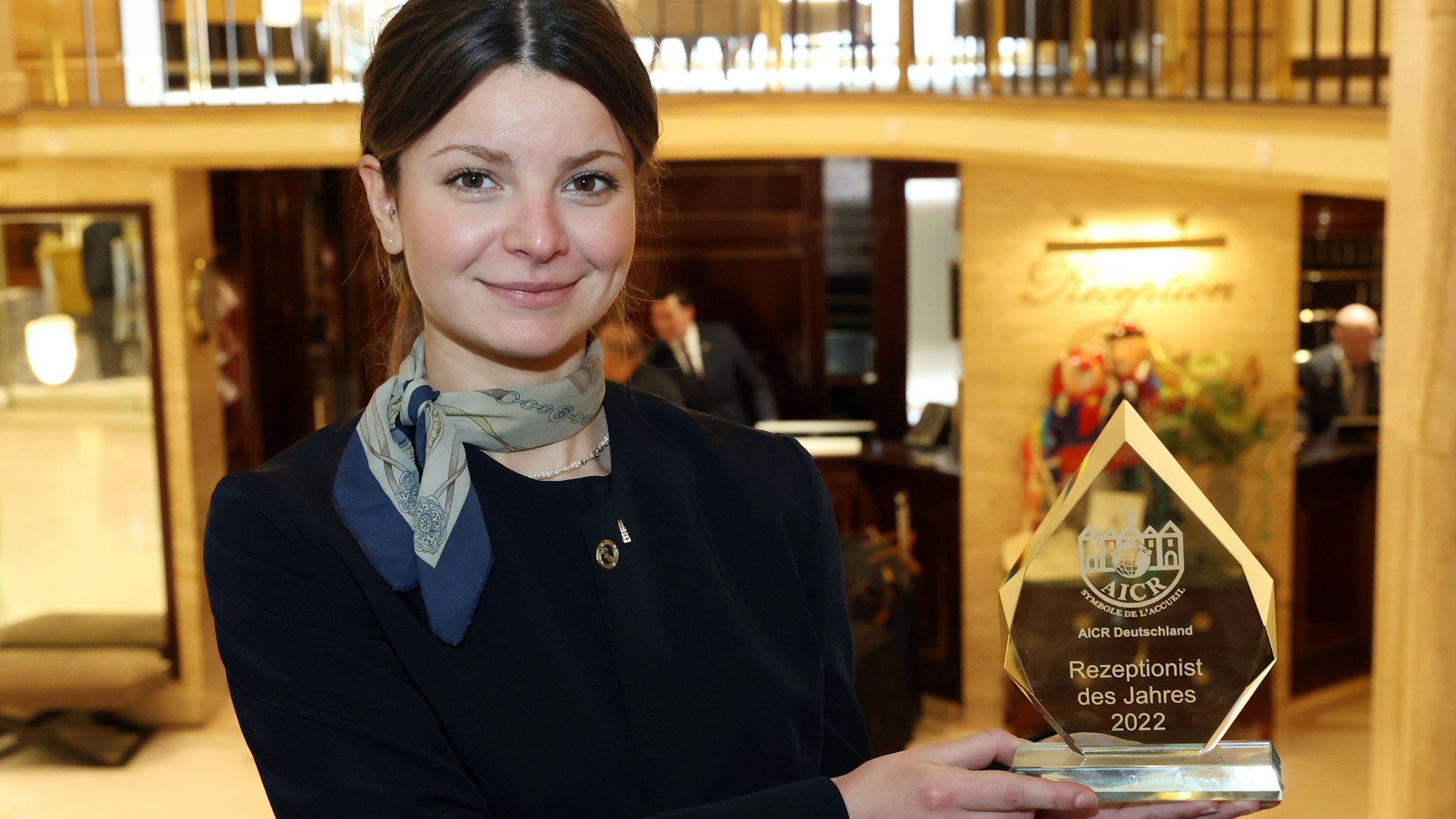 Lea Zimmermann mit ihrer Auszeichnung vor der Rezeption des Excelsior Hotel