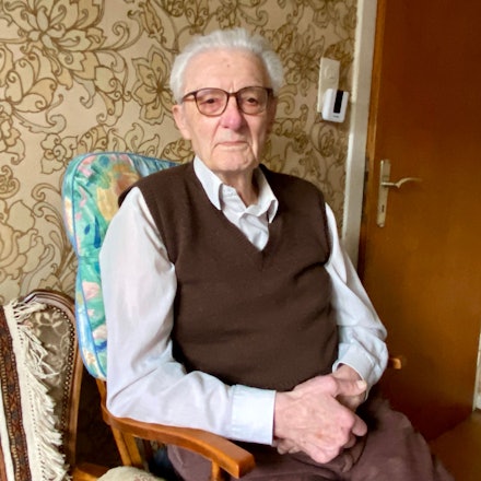 Karl Romberg sitzt auf einem Stuhl.