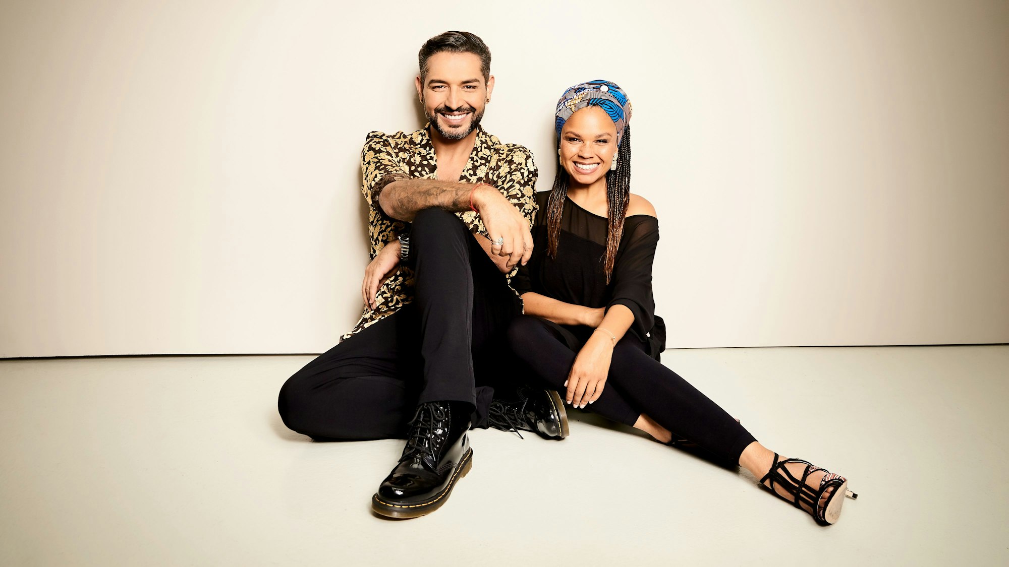 Ein Mann und eine Frau lehnen zusammen an einer Wand.