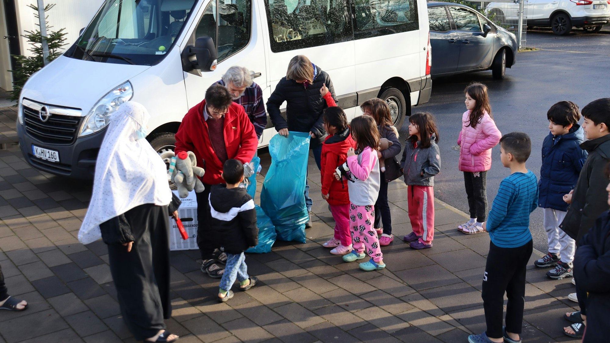 Mitglieder des Hilfsvereins Mosaik verteilen unter anderem Spielzeug an einige Kinder in den Flüchtlingsunterkünften.