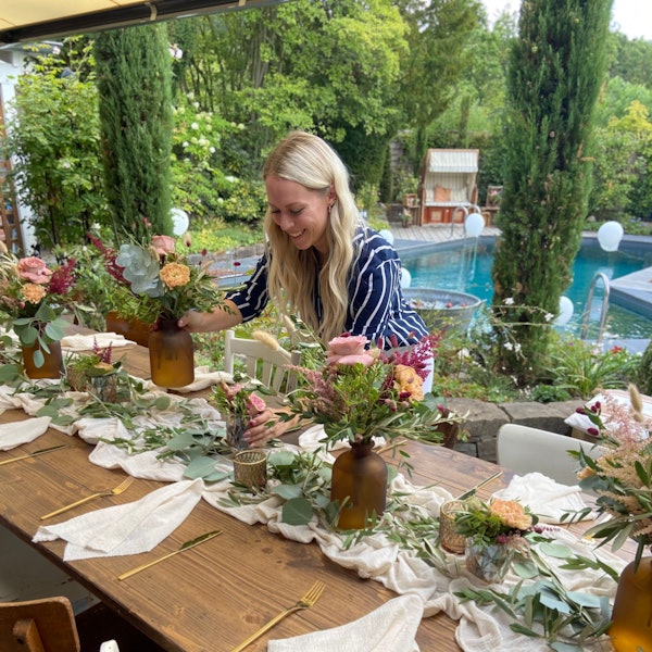 Eine Hochzeitsplanerin dekoriert einen Tisch.