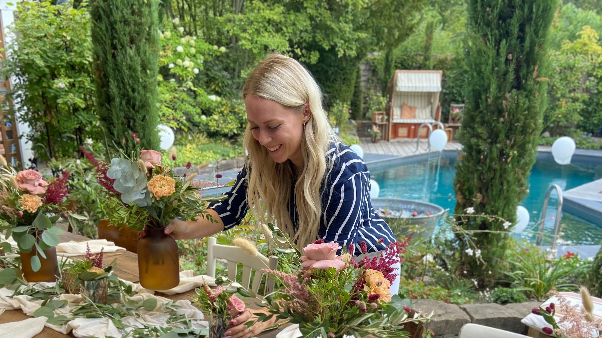 Eine Hochzeitsplanerin dekoriert einen Tisch.