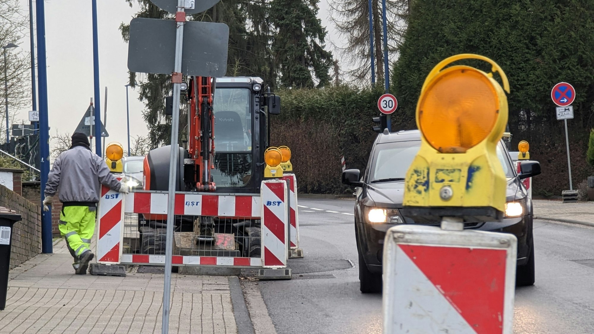 Man sieht eine Straße, auf der Baustellenabsperrungen einseitig die Fahrbahn verengen.