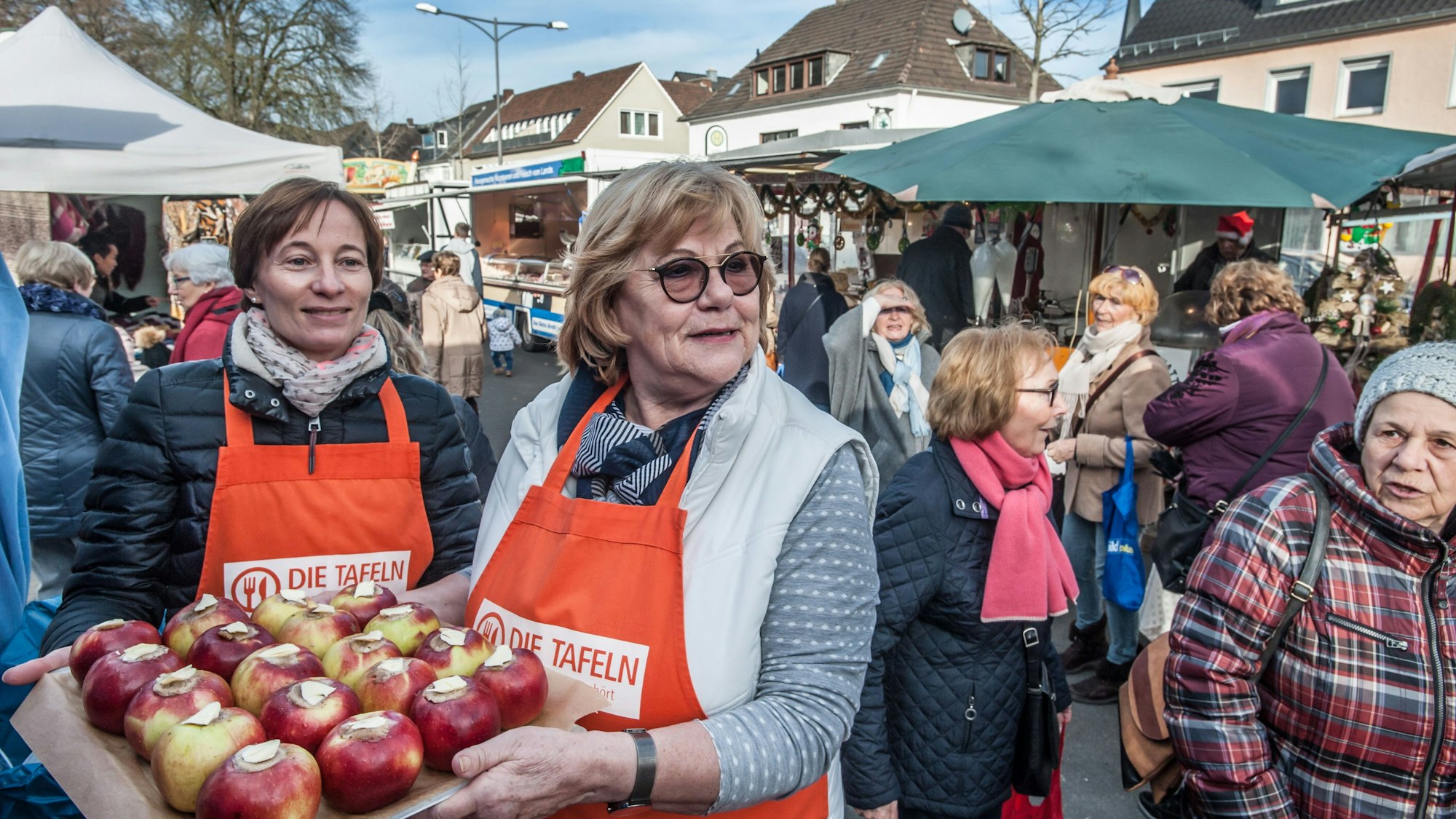 Judith Schewior und Helga Paul verteilen Bratäpfel.