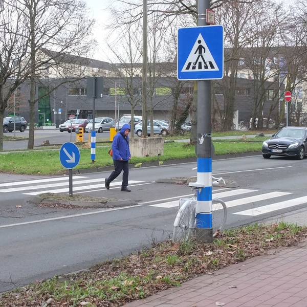 Der Zebrastreifen auf der Äußeren Kanalstraße mit einem Fußgänger und Auto.