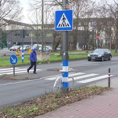 Der Zebrastreifen auf der Äußeren Kanalstraße mit einem Fußgänger und Auto.