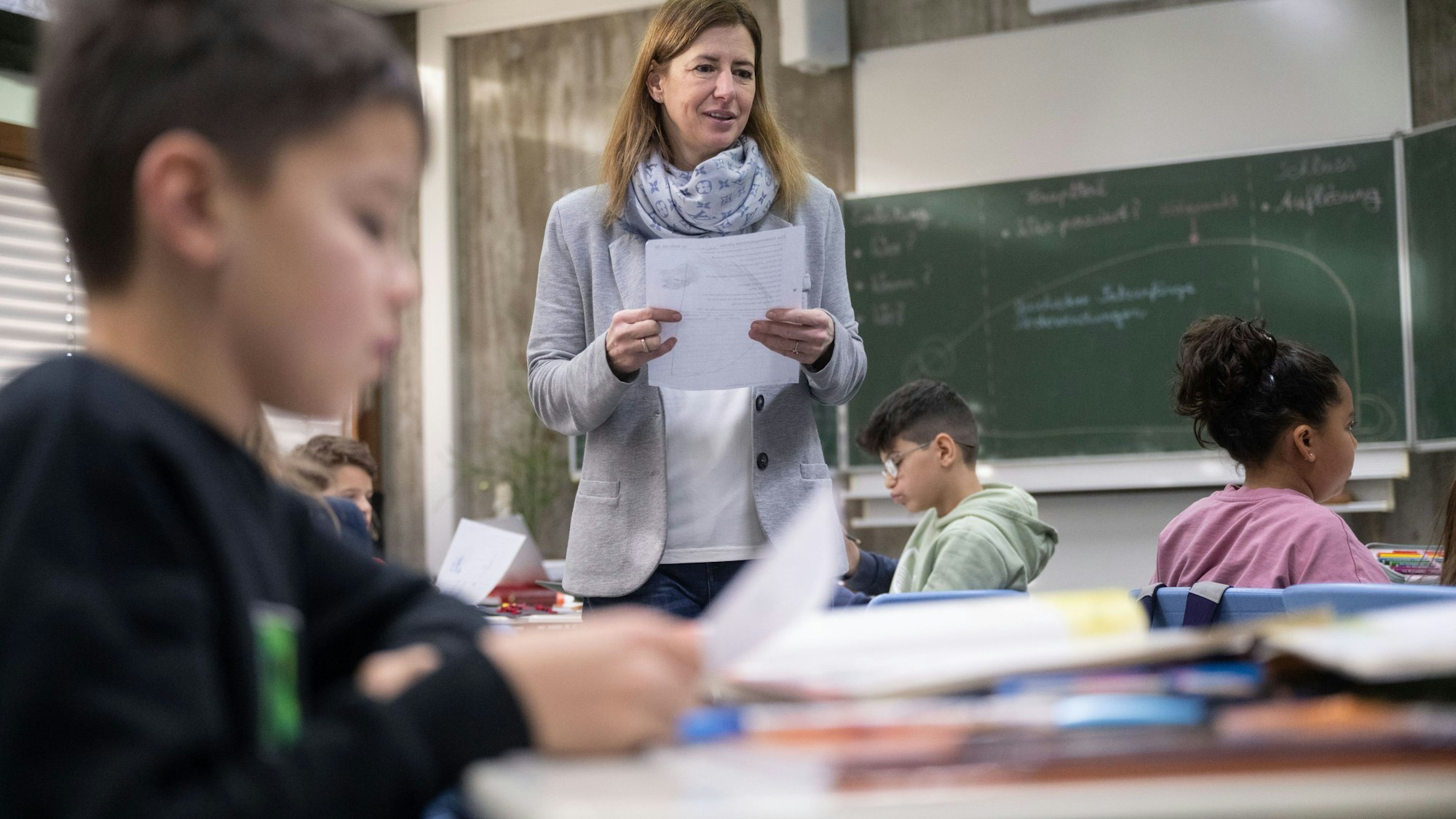 Das Bild zeigt eine Lehrerin, die eine vierte Klasse unterrichtet. An den Schulen gibt es zu wenige Lehrkräfte.