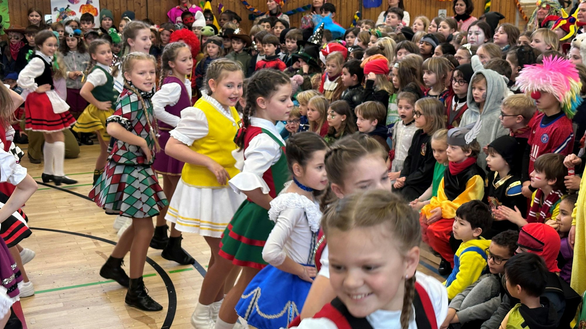 Mädchen aus Kölner Kindertanzgruppen tanzen bei„ Pänz große Pause“ in der KGS Stenzelbergstraße. Verkleidete Schüler schauen zu.