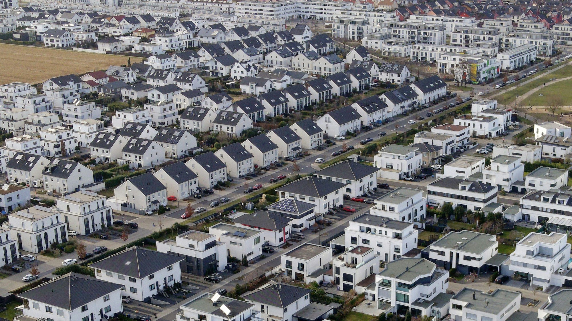 Mit einer Drohne wurden weiße Einfamilienhäuser in einer Siedlung in Köln-Widdersdorf aufgenommen.