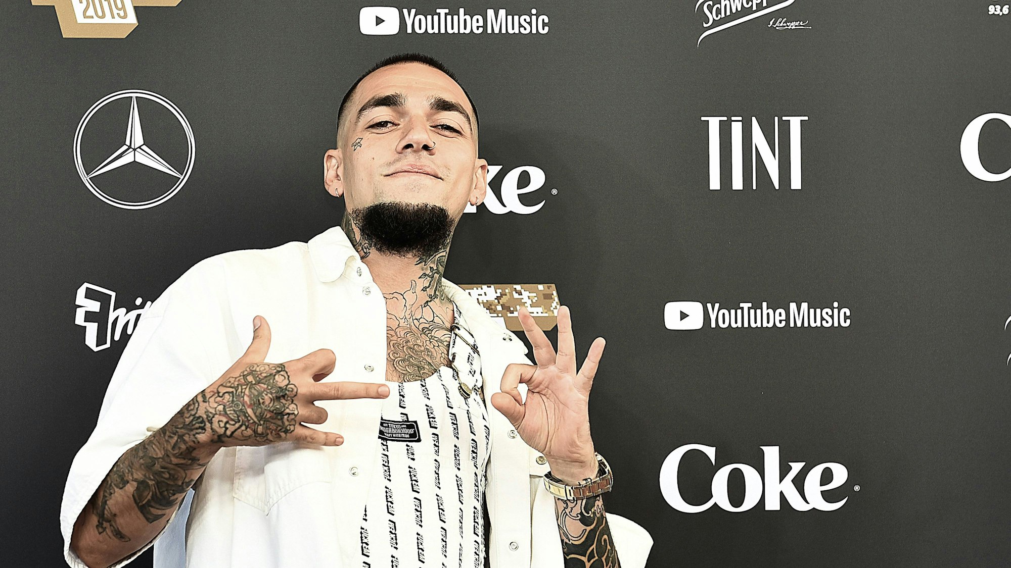 Ezhel vor einer Sponsorenwand.