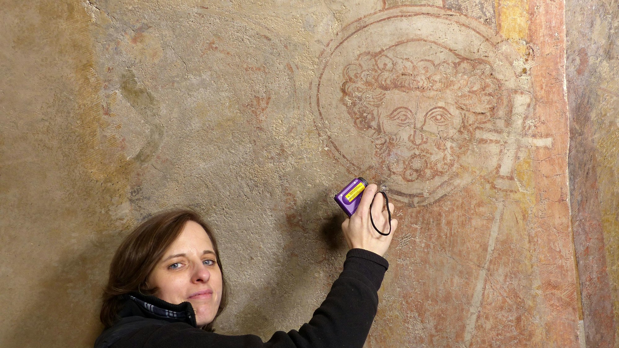 Die Kölner Diplom-Restauratorin Birgit Schwieder mit dem Bildnis des Heiligen Petrus an der Chordecke der Basilika