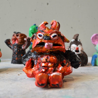 Eine finster guckende Gestalt aus Ton ist im Bürgerdorf am Alsberg ausgestellt.