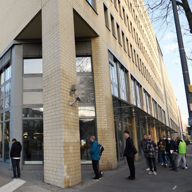 Das Bild zeigt eine lange Warteschlange vor dem Bürgeramt des Bezirksrathauses Lindenthal.