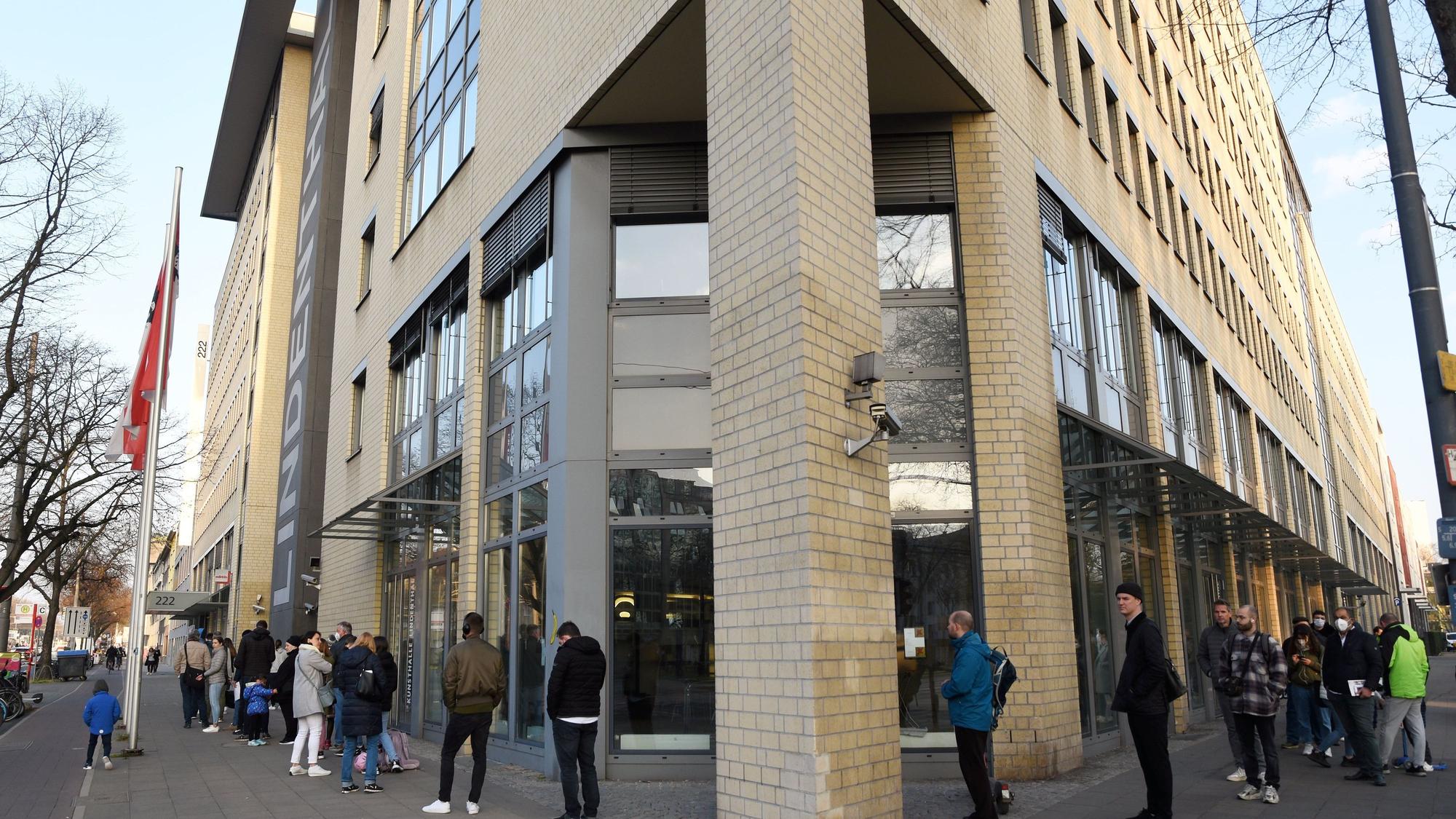 Das Bild zeigt eine lange Warteschlange vor dem Bürgeramt des Bezirksrathauses Lindenthal.