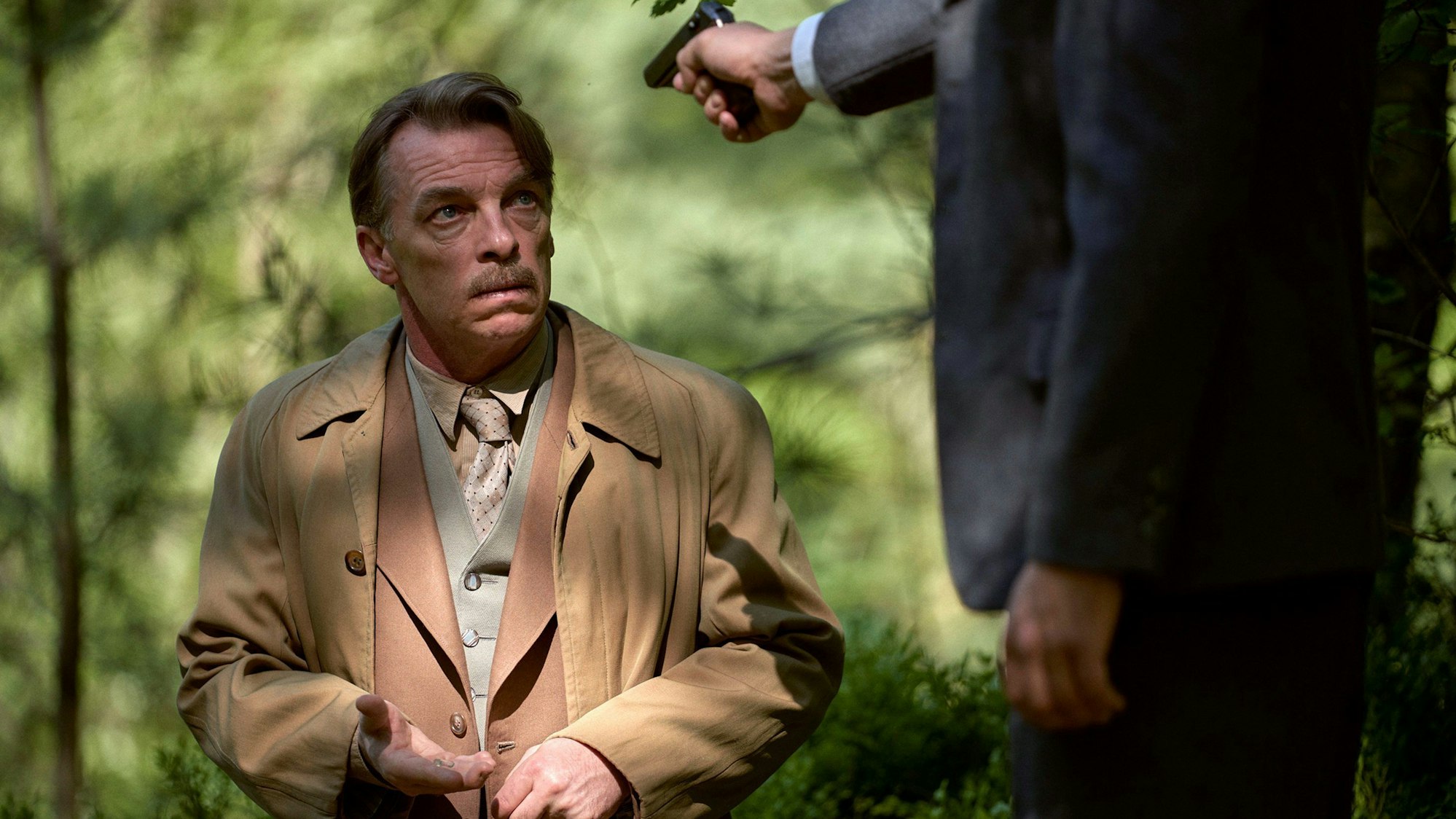 Wolfgang Berns (Max Riemelt, r) droht Alois Brunner (Andre Eisermann) ihn zu erschießen in Folge sechs der ARD-Mini-Historienserie «Bonn · Alte Freunde, neue Feinde»