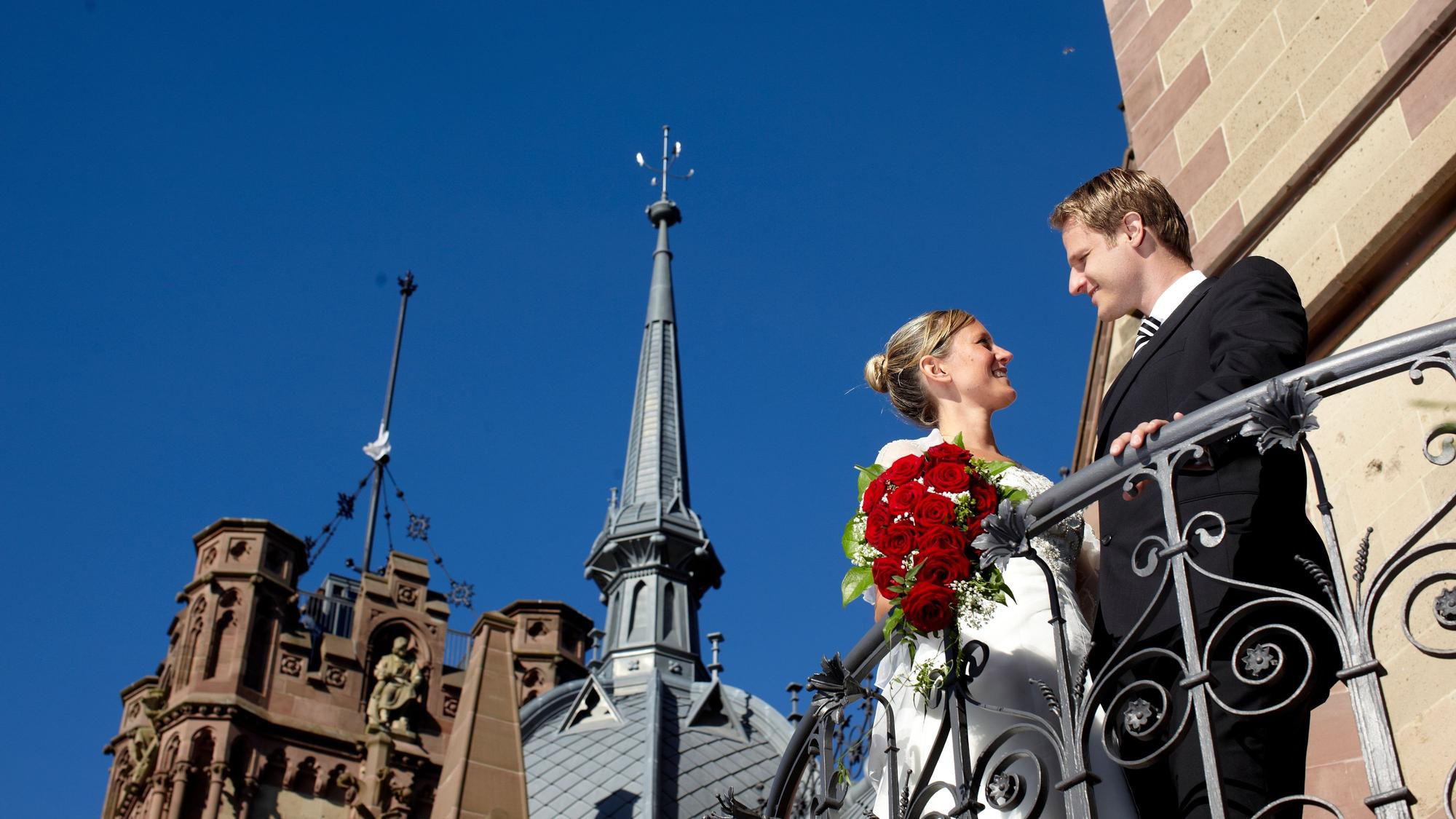 Ein Hochzeitspaar steht vor Schloss Drachenburg in Königswinter.