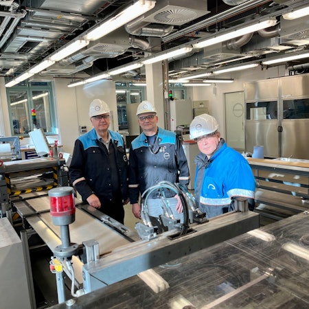 Andreas Bulan, Roberto Warthe und Michael Großholz von Covestro stehen an einer selbst konstruierten Anlage, auf der Sauerstoff-Verzehrkathoden gebaut werden.