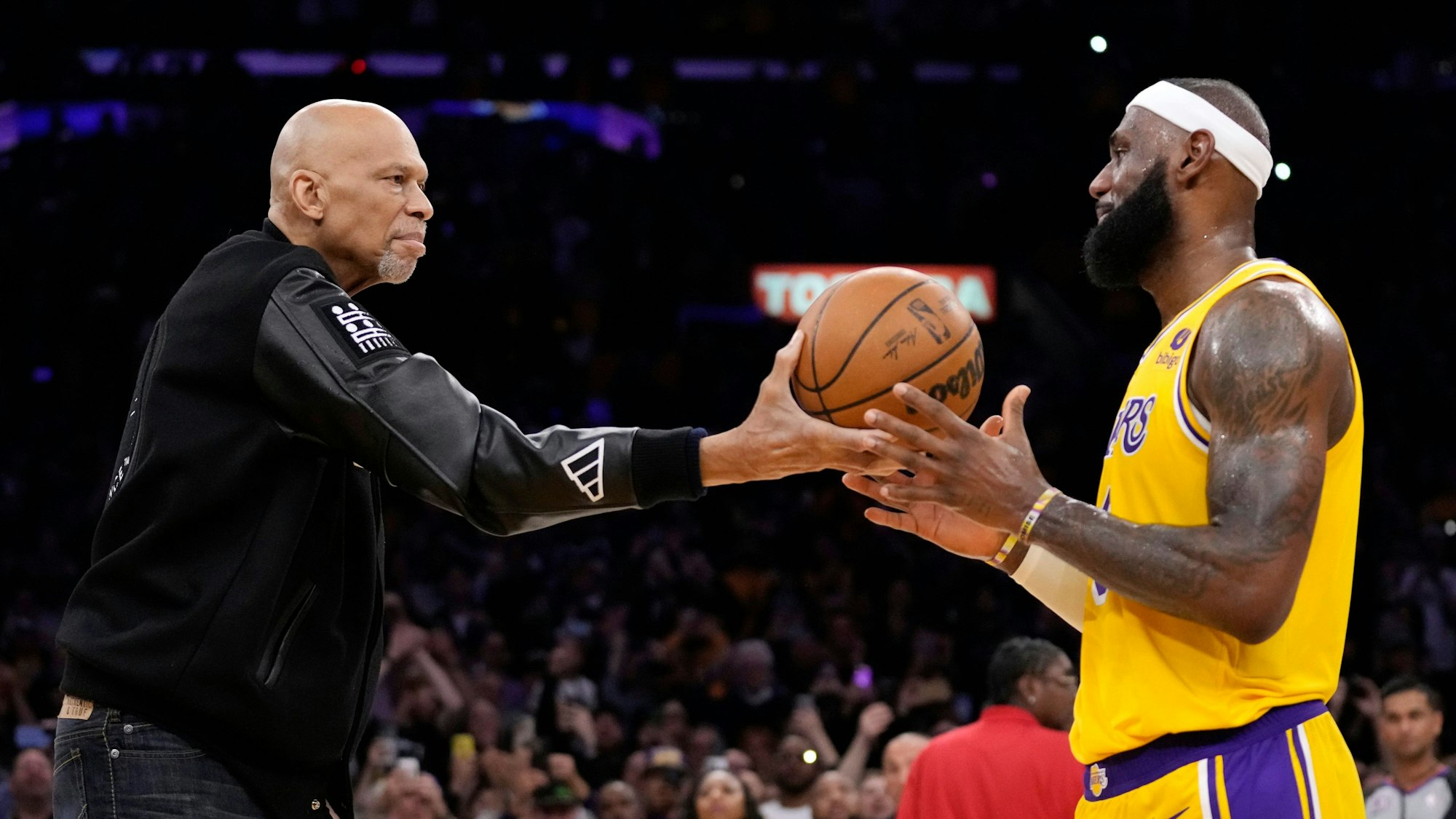 Symbolisch: Kareem Abdul-Jabbar reicht den Basketball an den neuen Rekordhalter LeBron James weiter.