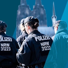 Polizisten einer Hundertschaft gehen hintereinander her.