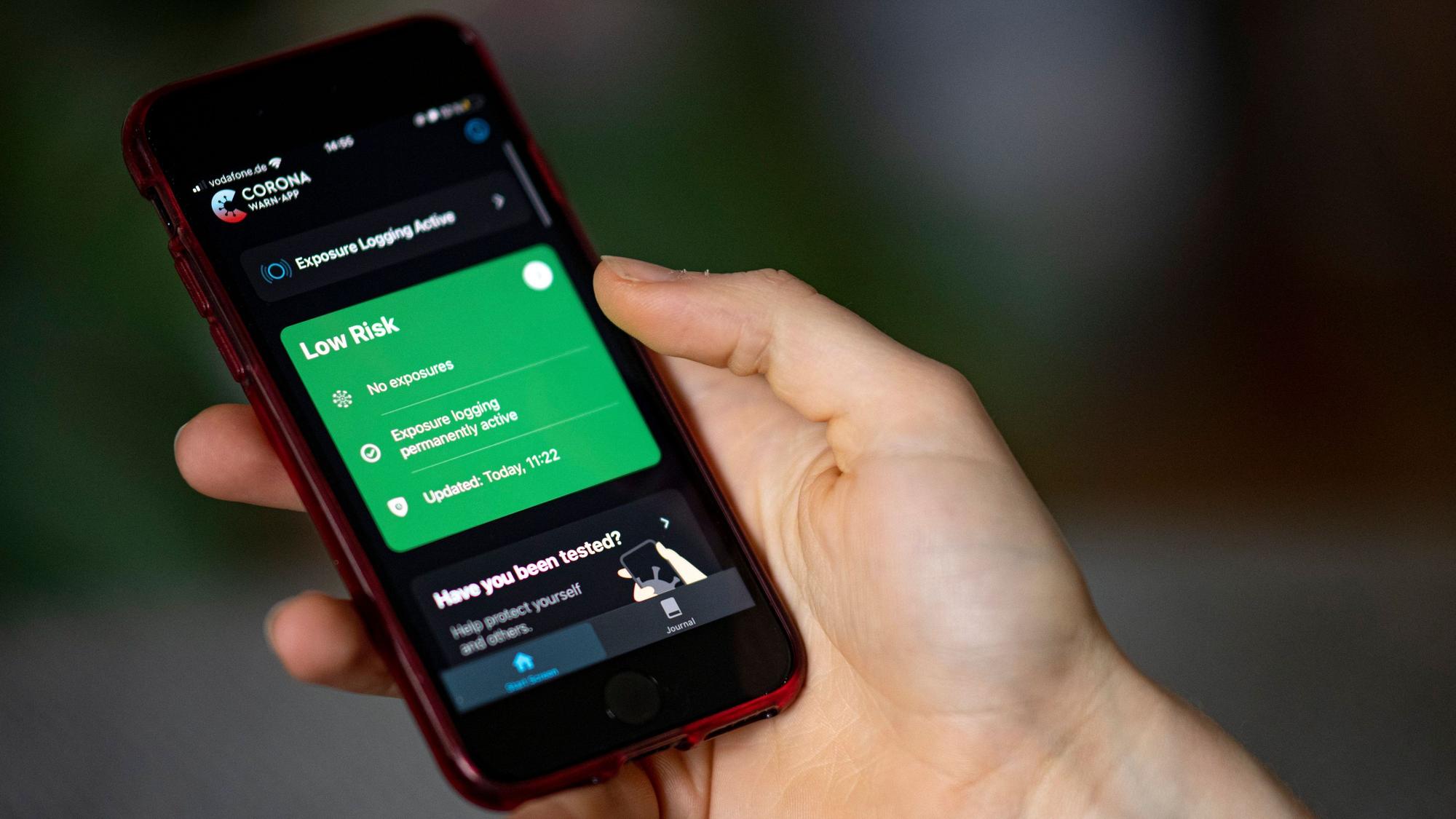Eine Person bedient mit ihrem Smartphone die Corona-Warn App.