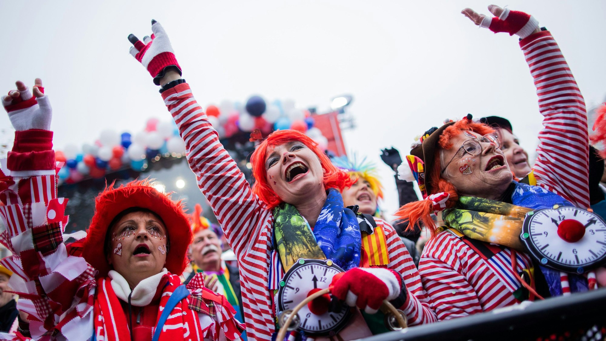 Es sind mehrere verkleidete Menschen zu sehen, die Karneval feiern.