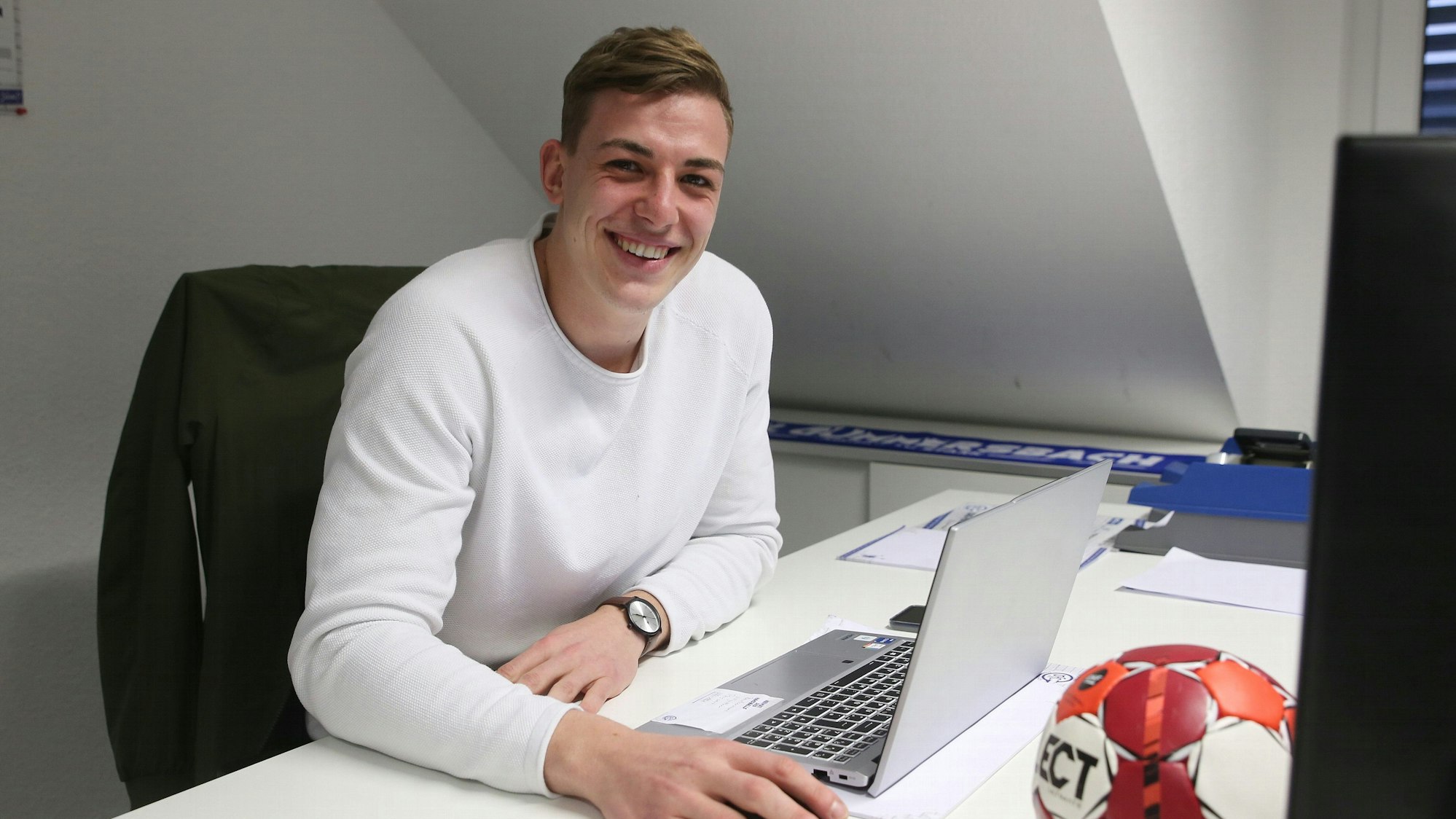 Blick auf einen jungen Mann am Schreibtisch.